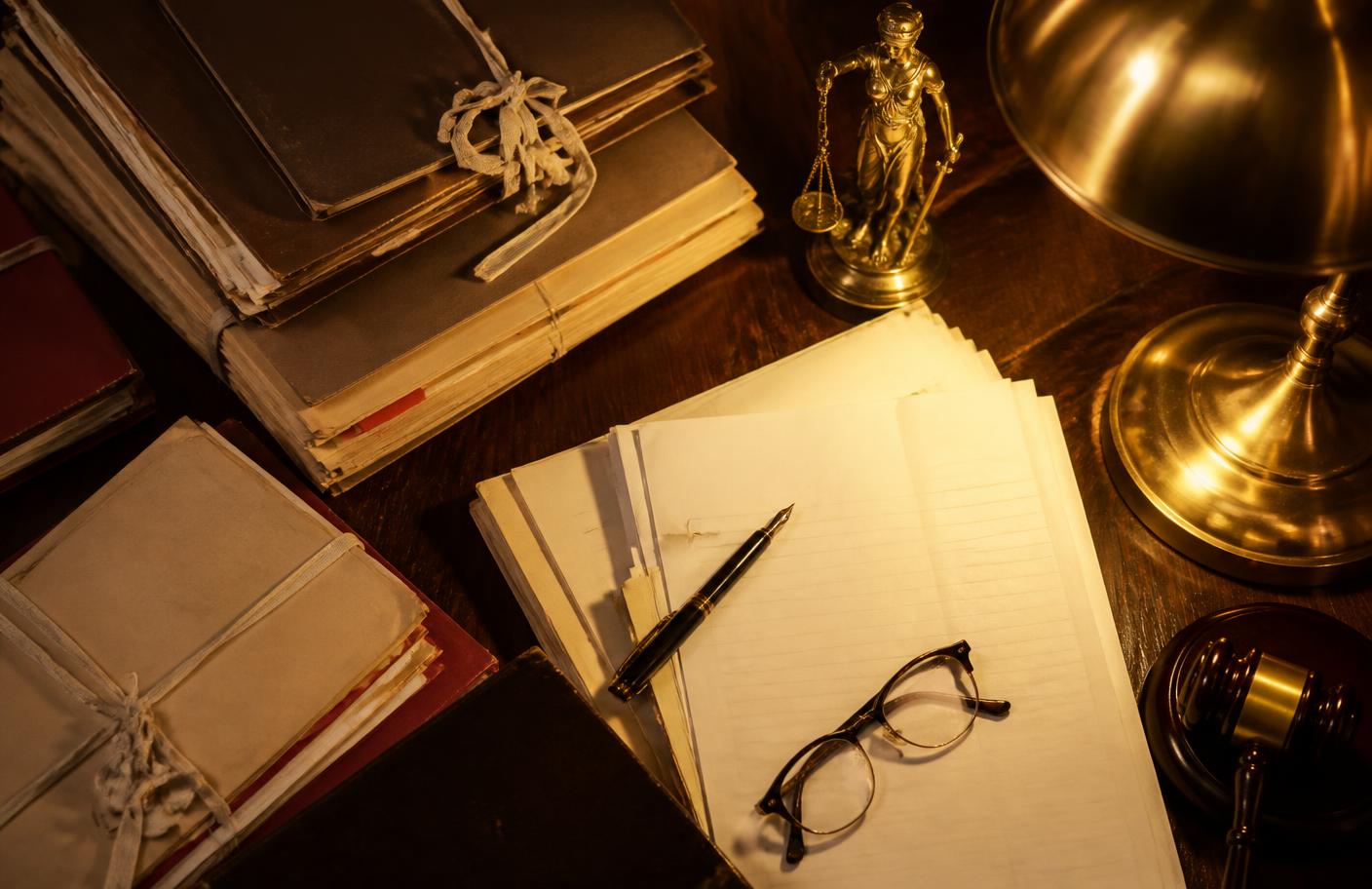 Court case files, pleadings and a pen arranged on an advocate's desk during case preparation